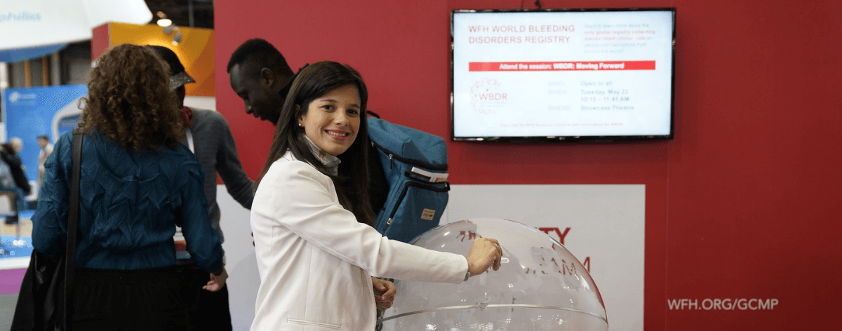 Una mujer deposita un donativo en un gran globo transparente.